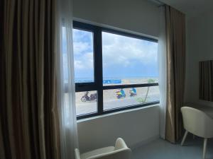 Zimmer mit einem Fenster und Strandblick in der Unterkunft Island Sunset Hotel - Đảo Phú Quý in Cu Lao Thu
