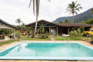 a swimming pool in front of a house at SURFSIDE MARESIAS in São Sebastião