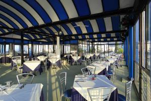 a dining room with white tables and chairs at San Domenico Hotel in Soverato Marina