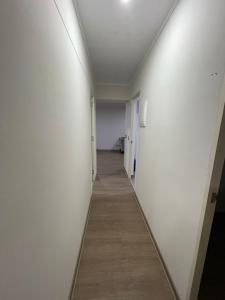 een lange hal met witte muren en een houten vloer bij Sauvi Ocean in Lima