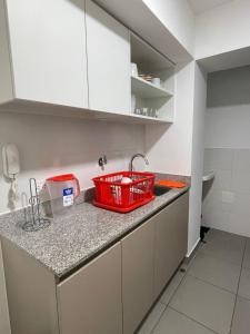 een keuken met een wastafel en een rode mand op een aanrecht bij Sauvi Ocean in Lima