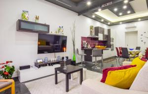 a living room with a couch and a tv and a table at 2 Bedroom Awesome Home In Mitogio in Gaggi