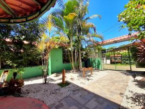 a courtyard with a green building and palm trees at Casa Nelly Apartamentos in Sámara