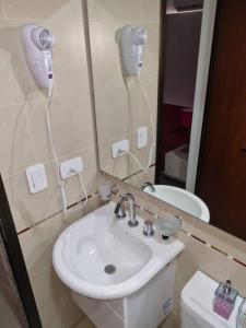 a bathroom with a sink and a mirror and a toilet at Apart dos ambientes - Macrocentro Salta in Salta