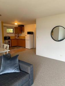 a living room with a couch and a mirror at Apartment minutes to Lake in Jindabyne