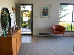 a living room with a dresser and a chair at Apartment minutes to Lake in Jindabyne