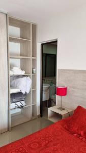 a bedroom with a red bed and a red lamp at Apart dos ambientes - Macrocentro Salta in Salta
