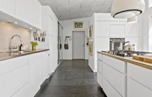 a kitchen with white cabinets and a long hallway at Stunning Home In Bedsted Thy With Wifi in Bedsted Thy +16 photos