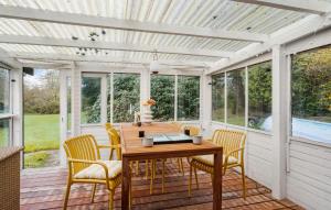 - une terrasse couverte avec une table et des chaises en bois dans l'établissement Beautiful Home In Or With Wifi, à Orø