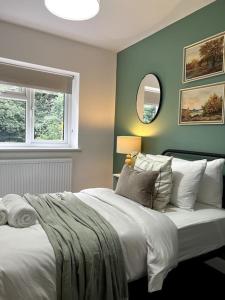 - une chambre avec un lit blanc et un mur vert dans l'établissement 4 Bedroom House Coventry Sleep 7 with 3 Parking Spaces, à Coventry