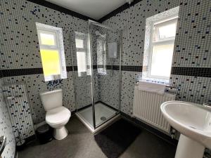 ein Bad mit einer Dusche, einem WC und einem Waschbecken in der Unterkunft 4 Bedroom House Coventry Sleep 7 with 3 Parking Spaces in Coventry