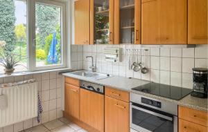 cocina con armarios de madera, fregadero y ventana en Nice Home In Kilder With Kitchen, en Kilder