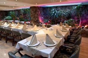 a group of tables in a banquet hall with white table settings at Centro Internacional Apartahotel in Bogotá