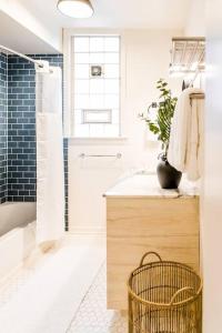 un bagno con vasca, lavandino e doccia di Cozy Cottage Downtown - Walk to OTR & Stadiums a Cincinnati