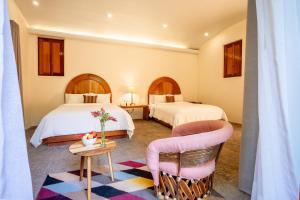 a hotel room with two beds and a table and chairs at Mision del Sol Resort & Spa in Cuernavaca