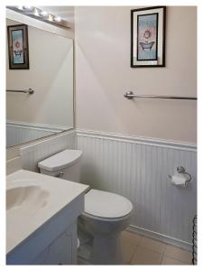 a white bathroom with a toilet and a sink at Modern Comfort Stays in Alexandria