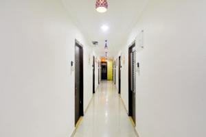um corredor de um hospital com portas negras e paredes brancas em Super OYO Flagship Relax Grand Near Snow World em Hyderabad
