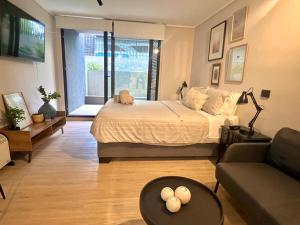 ein Schlafzimmer mit einem Bett und ein Wohnzimmer mit einem Sofa in der Unterkunft Studio nuevo full equipado en Las Condes in Santiago