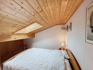 Schlafzimmer mit einem Bett mit Holzdecke in der Unterkunft Appartement Combloux, 4 pièces, 6 personnes - FR-1-560-133 in Combloux