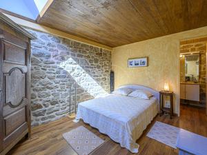 - une chambre avec un lit et un mur en pierre dans l'établissement Villa Étel, 7 pièces, 8 personnes - FR-1-479-162, à Étel