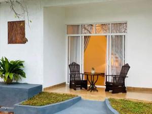 un patio con 2 sillas y una mesa en una casa en Dhanwanthari Bhawan Ayurvedic Retreat, en Habarana