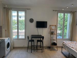 a bedroom with a table and chairs and a bed at Logement complet à proximité de Paris in Le Blanc-Mesnil