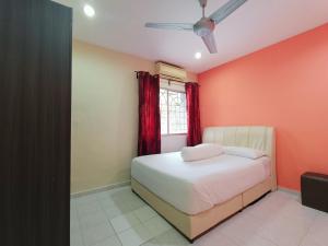 a bedroom with a bed and a red wall at Juwita Homestay Bukit Katil - Free Unifi and 15 Minutes To Town in Melaka