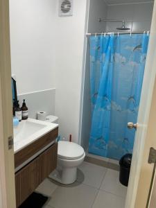een badkamer met een toilet en een blauw douchegordijn bij Sauvi Ocean in Lima