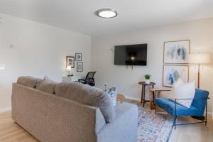 een woonkamer met een bank en een tafel bij NEW! Comfy 1 Bedroom Flat I Hollywood Suites in Mount Clemens