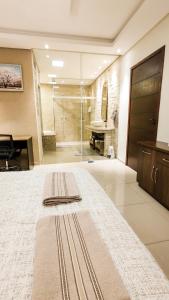 a large bathroom with a large bed and a shower at Linda Casa em Santa Felicidade in Curitiba