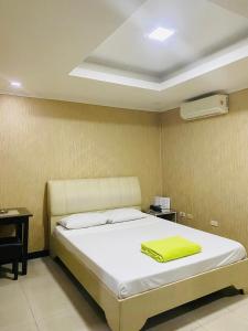 a bedroom with a bed with a yellow towel on it at PJ INN HOTEL in Angeles +9 photos