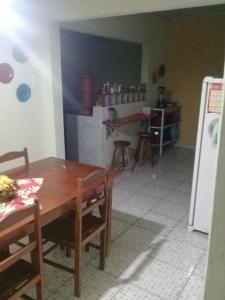 Il comprend une cuisine équipée d'une table en bois et d'un réfrigérateur. dans l'établissement Casa Ampla, à Passa Quatro