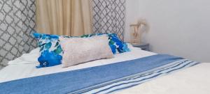 a bed with blue and white sheets and a pillow at Casa Calis Cancún in Cancún