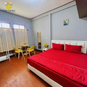 Un dormitorio con una gran cama roja y una mesa en Magic Garden Residence Bangkok, en Bangkok