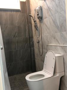 a bathroom with a shower with a toilet and a phone at ONYX Café & Hostel in Betong