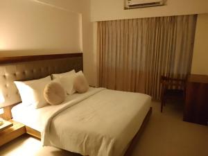a bedroom with a bed with white sheets and pillows at Entire 3 bhk by The Good Traveller in Mumbai
