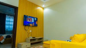 ein Wohnzimmer mit einem gelben Sofa und einem TV an der Wand in der Unterkunft Mountain view apartment 