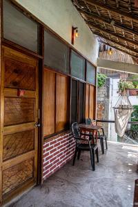 eine Veranda mit einer Holztür sowie einem Tisch und Stühlen in der Unterkunft Hotel Manava in Brisas de Zicatela