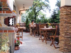 a woman sitting at a table on a patio at Family Hotel Emaly 2 in Sapareva Banya