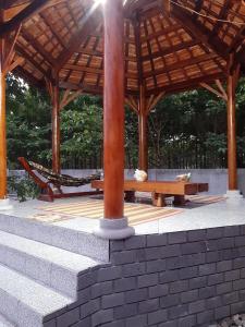 un pabellón de madera con mesa de picnic y banco en Du Nam Riverside Tour Trọn Gói, en Tân Phú