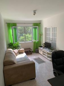sala de estar con cortinas verdes y sofá en Apartamento Aconchegante na Zona Sul, Botafogo Rj, en Río de Janeiro