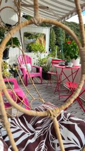 un groupe de chaises et de tables roses sur une terrasse dans l'établissement Paihia Loft Walk to Beach, Eats and Culture, à Paihia