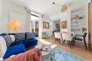 ロンドンにあるThe QUEEN of Marylebone - Luxury Victorian Apartmentのリビングルーム(青いソファ、ダイニングルーム付)