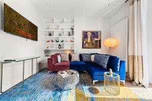 ロンドンにあるThe QUEEN of Marylebone - Luxury Victorian Apartmentの白い壁のリビングルーム(青いソファ付)