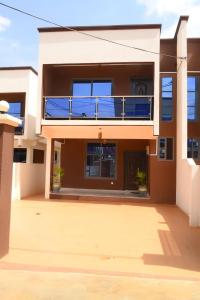 a house with a balcony in front of it at Luxury Townhome in Oyarifa in Oyarifa