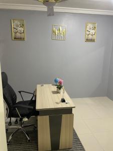 un escritorio con un jarrón de flores en una habitación en Luxury Townhome in Oyarifa, en Oyarifa