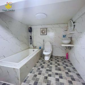 La salle de bains est pourvue d'une baignoire, de toilettes et d'un lavabo. dans l'établissement Magic Garden Residence Bangkok, à Bangkok