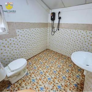 La salle de bains est pourvue de toilettes et d'un lavabo. dans l'établissement Magic Garden Residence Bangkok, à Bangkok