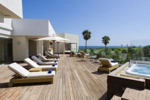 a patio with lounge chairs and a swimming pool at Iberostar Selection Diar El Andalous in Port El Kantaoui