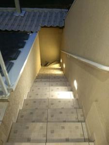 a stairway in a building with a tile floor at Linda Casa em Santa Felicidade in Curitiba